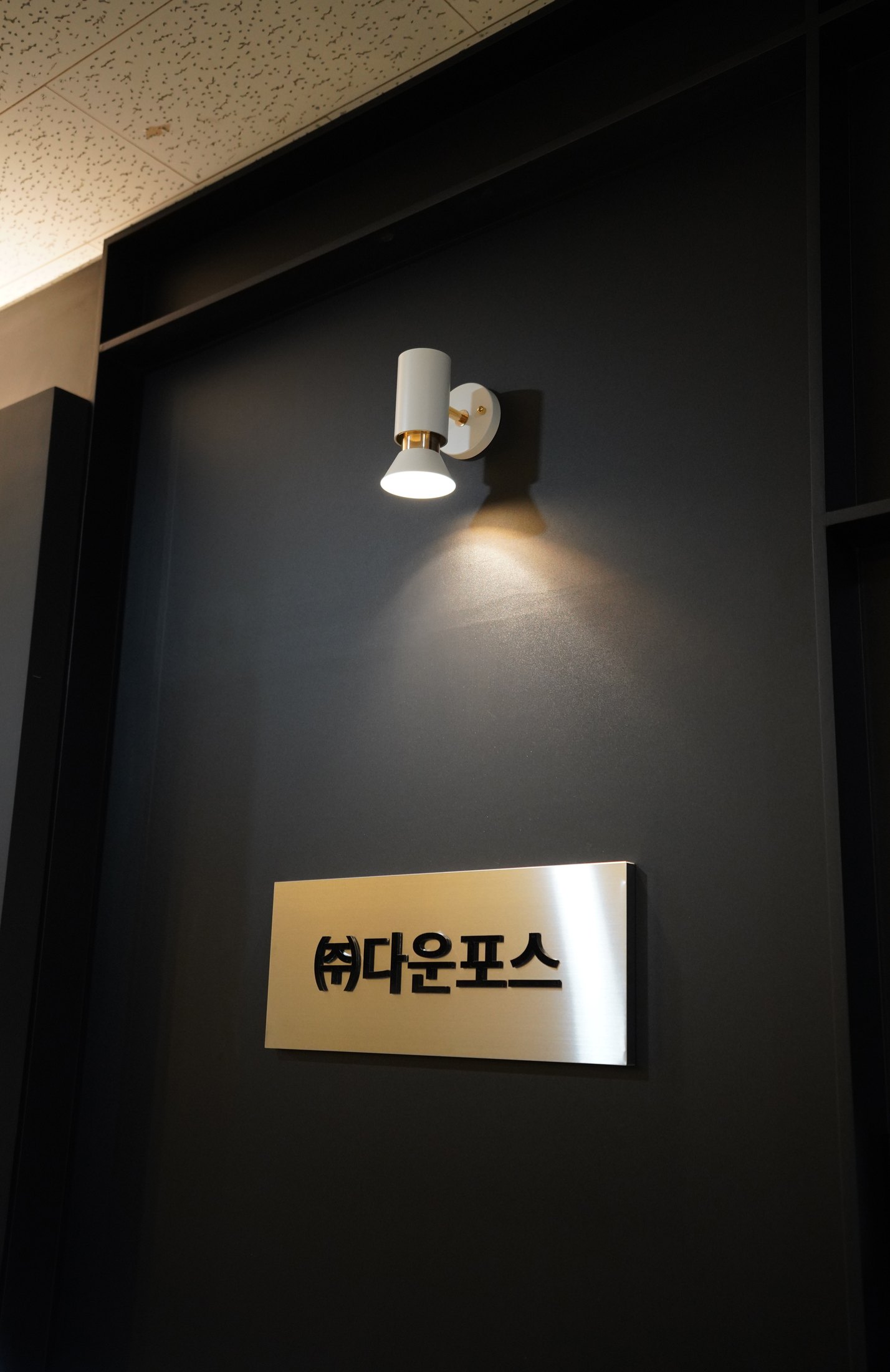 다운포스 사인과 벽 조명이 적용된 파사드 디테일