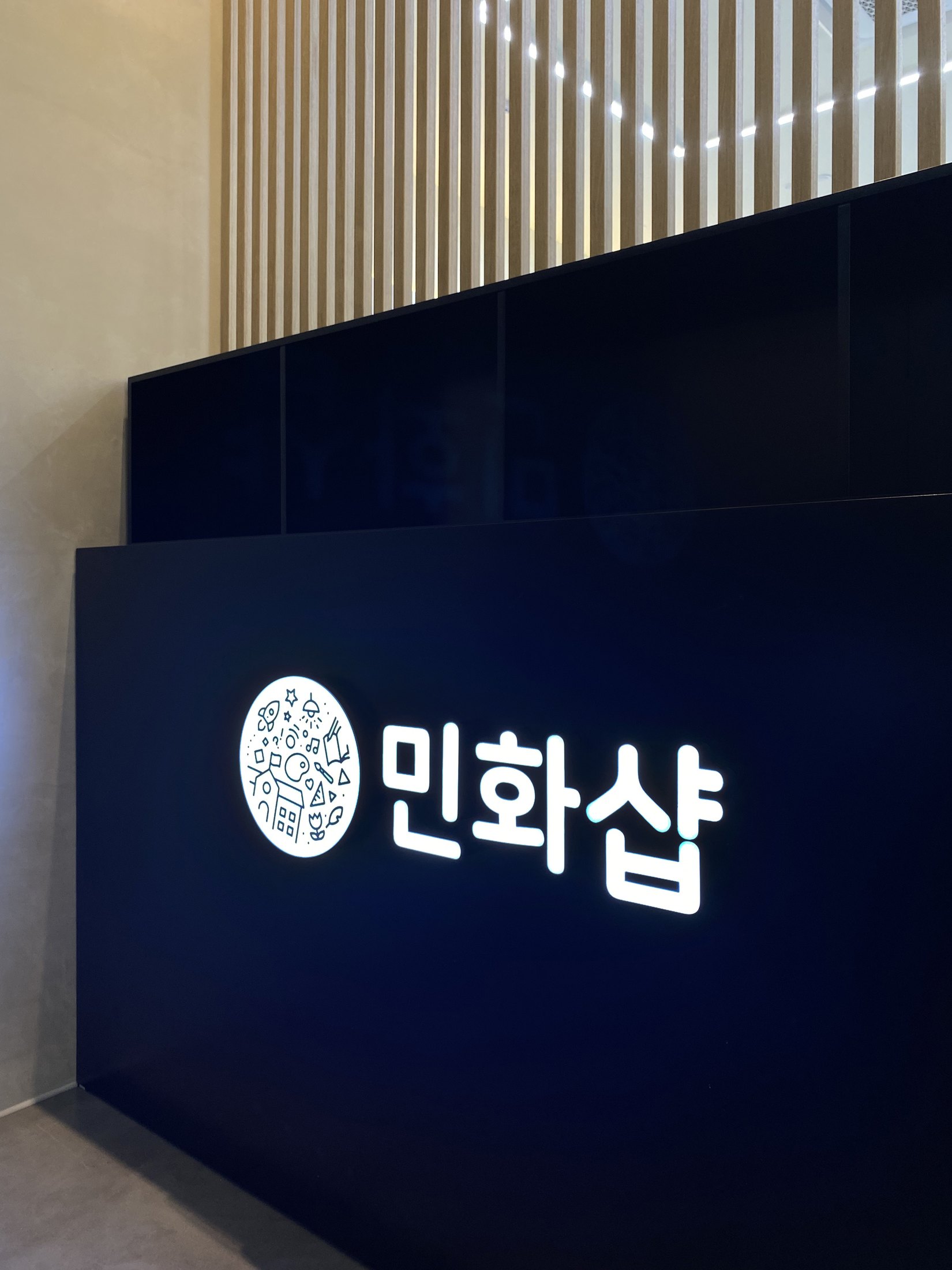 민화샵 로고가 적용된 블랙 리셉션 카운터 정면